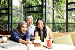 Asian Female Friends are Enjoying Eating food, Drinking, and Hanging Out at a Restaurant