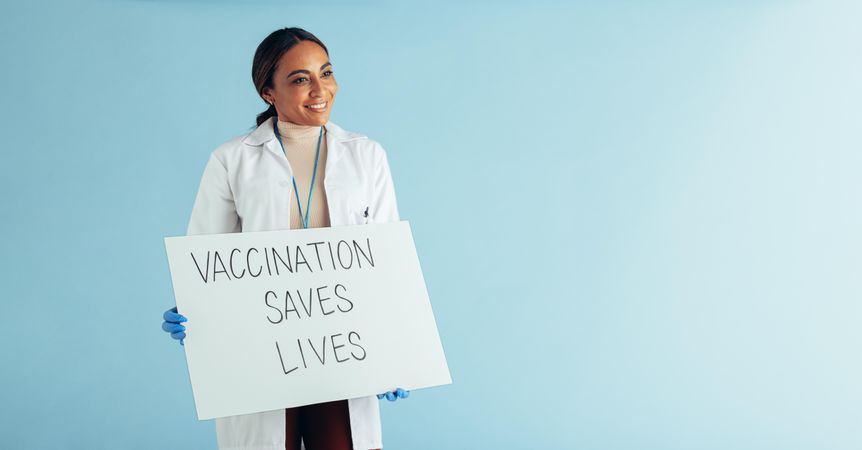 Healthcare professional showing vaccination awareness signboard