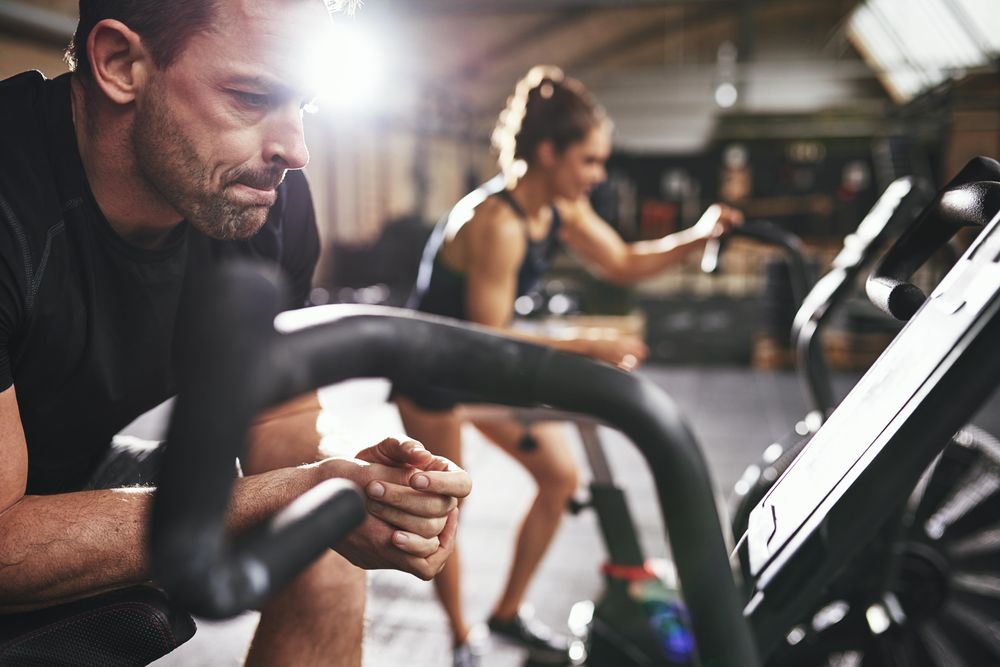 Tired male checking personal performance stats on cycling bike