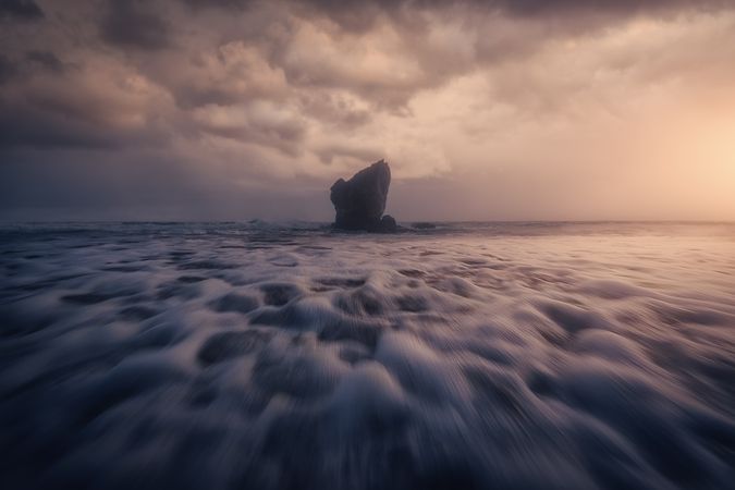 Coastal rock on beach and overcast sky