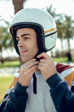 Man in motorcycle adjusting helmet