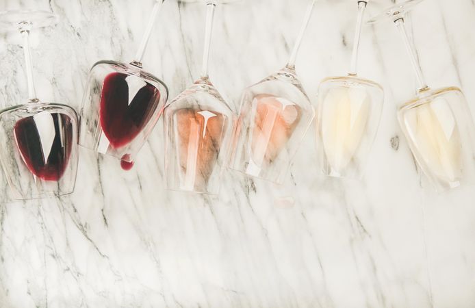 Glasses of wine laying on marble background, with copy space