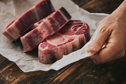 Close up of man with three steaks
