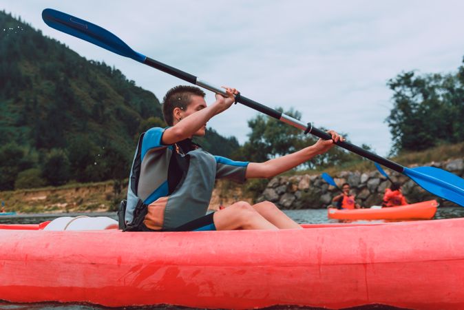 Young female kayaking on nature background