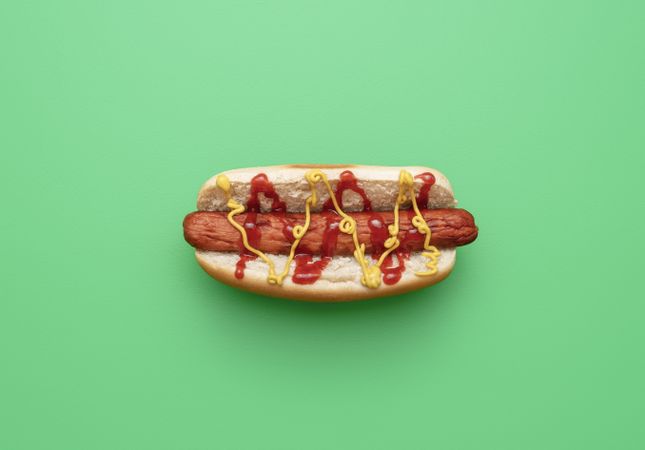 Hot dog top view minimalist on a green background