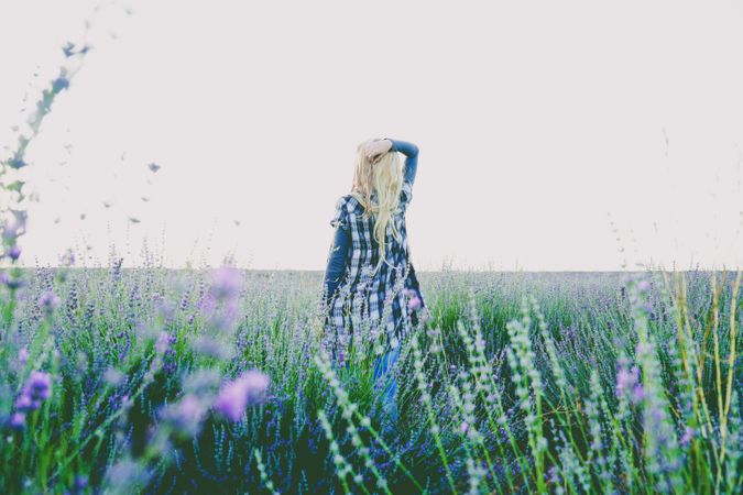Back view of woman standing in lavender flower field