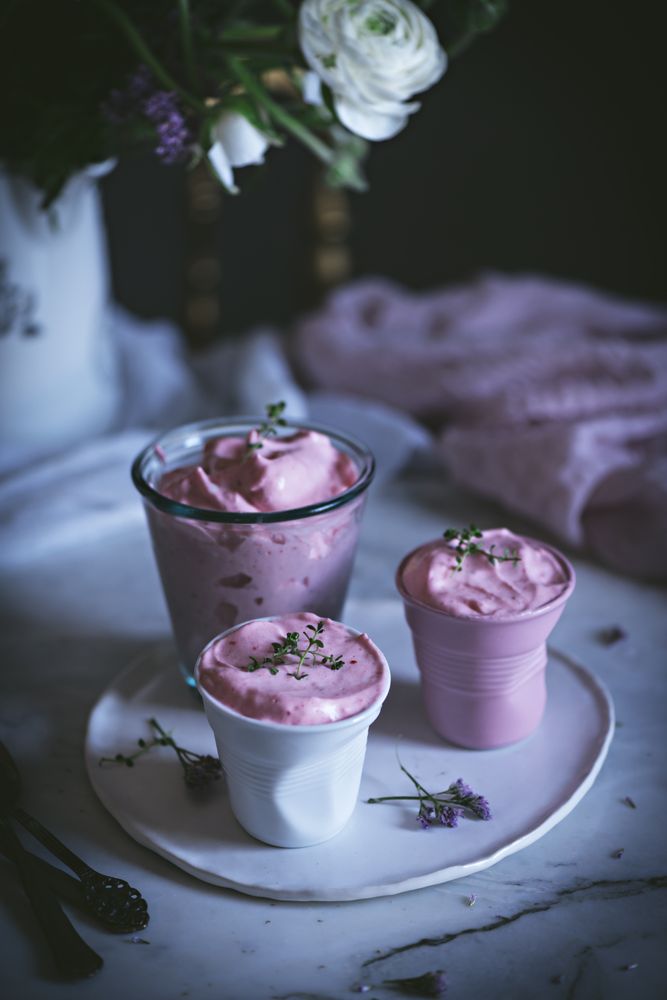 tasty glasses of strawberry mousse on a table with flowers