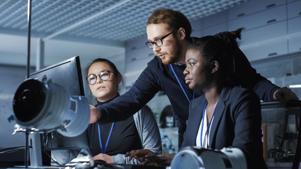 Black and White Female Scientists have Work Related Discussion, Male Researcher Joins Them.