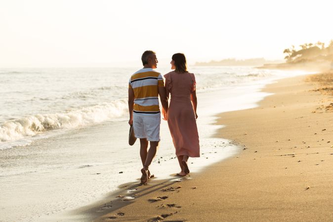 Adult couple walking towards sea