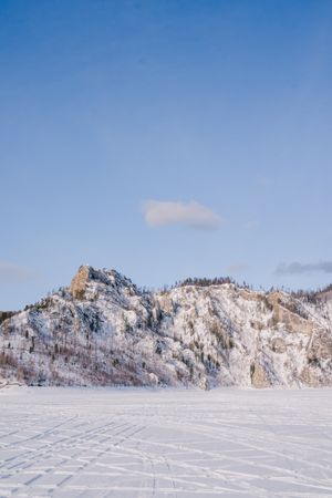 Winter landscape with snowy rocks and blue sky