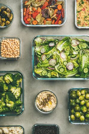 Variety of vegetable dishes arranged in in glass containers, vertical composotion