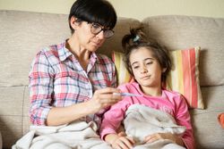Mother sitting with her sick daughter