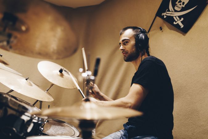 Man with headphones playing on drums
