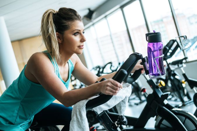 Woman with towel and water on exercise machine