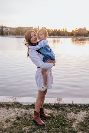 Mother and daughter standing near water