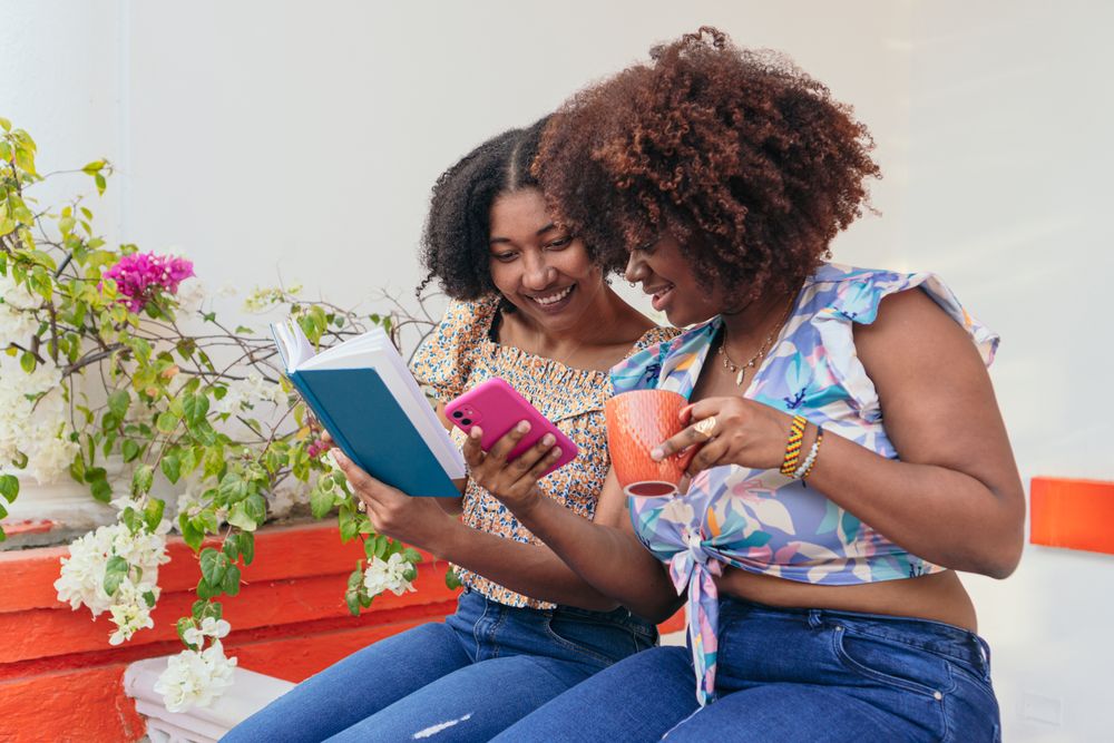 Women reading and checking the phone during the coffee break