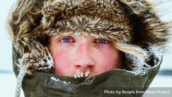 Close-up of man with blue eyes wearing parka jacket and covered with snow 5axGP0