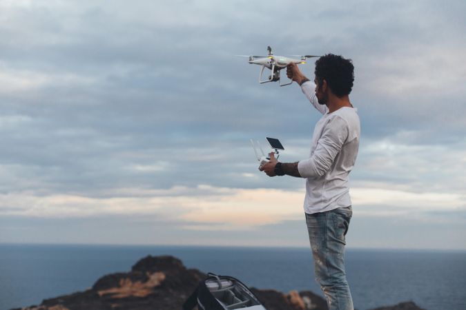 Man holding drone and remote on overcast day