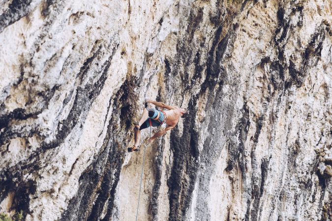 Anonymous man climbing rock