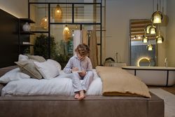 Concentrated boy writing in notepad on bed