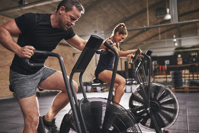 Couple doing intense crossfit class at modern indoor gym