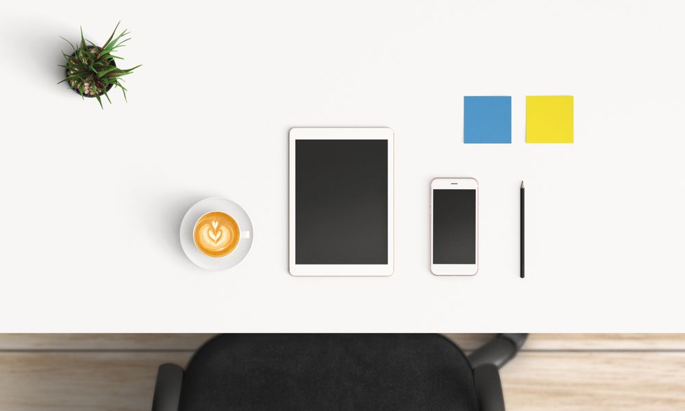 Modern workplace with coffee cup and smartphone or laptop copy space on table background. Top view. Flat lay style.
