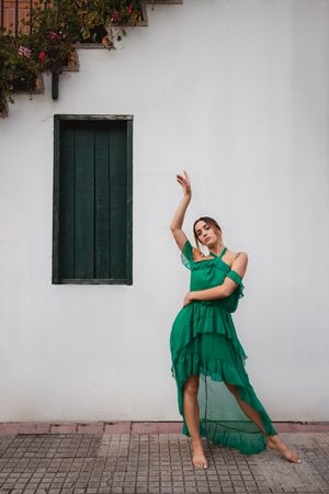 Barefoot woman leaning on house wall