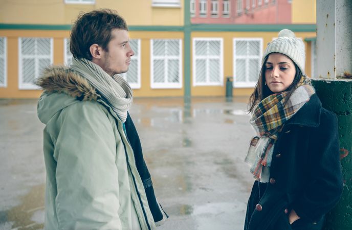 Couple standing apart after argument outside on cold day