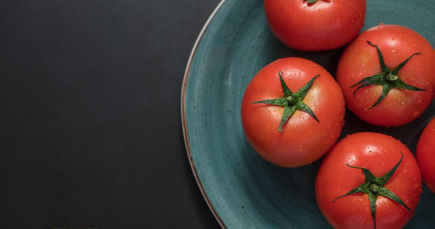 Closeup of ripe tomatoes placed in a ceramic plate