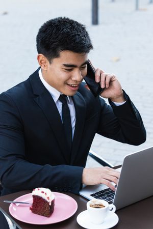 Cheerful businessman working in cafe
