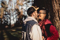 Happy couple hugging near tree in park