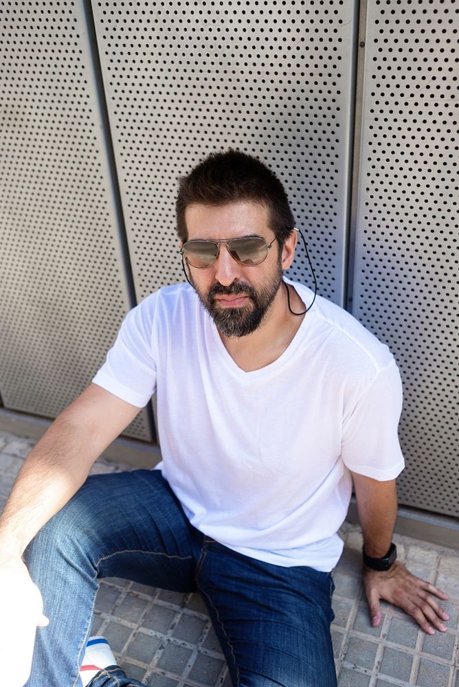 Man in sunglasses sitting on ground outside