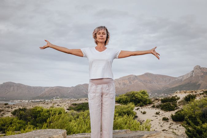 Barefoot woman meditating on stone