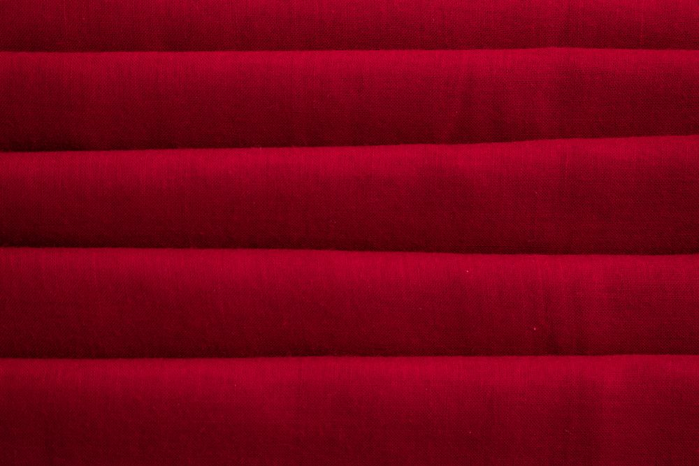 Close up Red folded Fabric Background Texture.