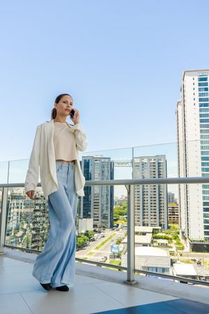 A businesswoman is talking on her cell phone while she walks.