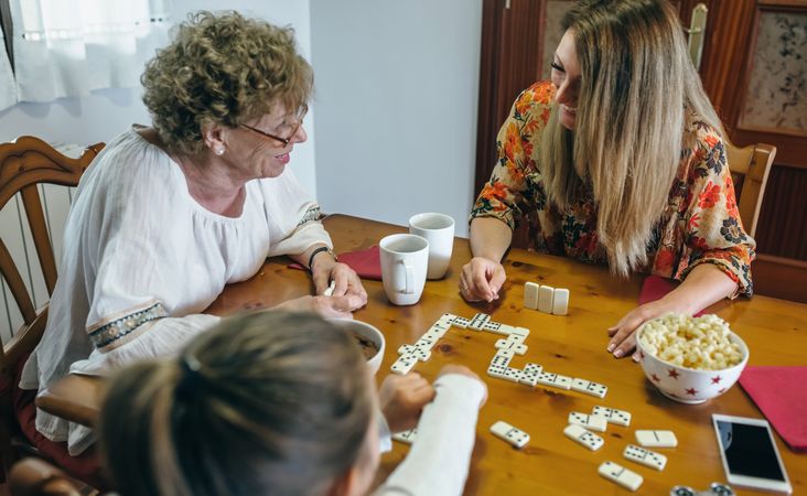 Three female generations playing domino