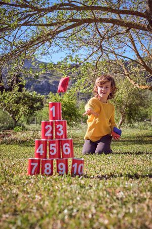 Little boy with knock down cans in park