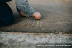 Child drawing squiggles with chalk outside 0ymoj0