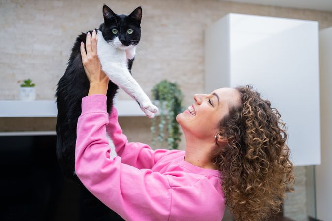 Smiling woman holding up her pet cat