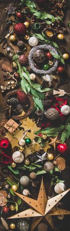 Holiday decorations of stars, baubles, leaves, scissors and ribbon, narrow composition