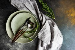 Top view of grey plate set with fresh rosemary