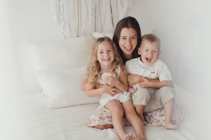 Content young mother with little kids at bedroom