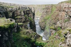 Man on edge of rugged cliff