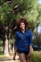 Happy with afro walking tall through park on sunny day
