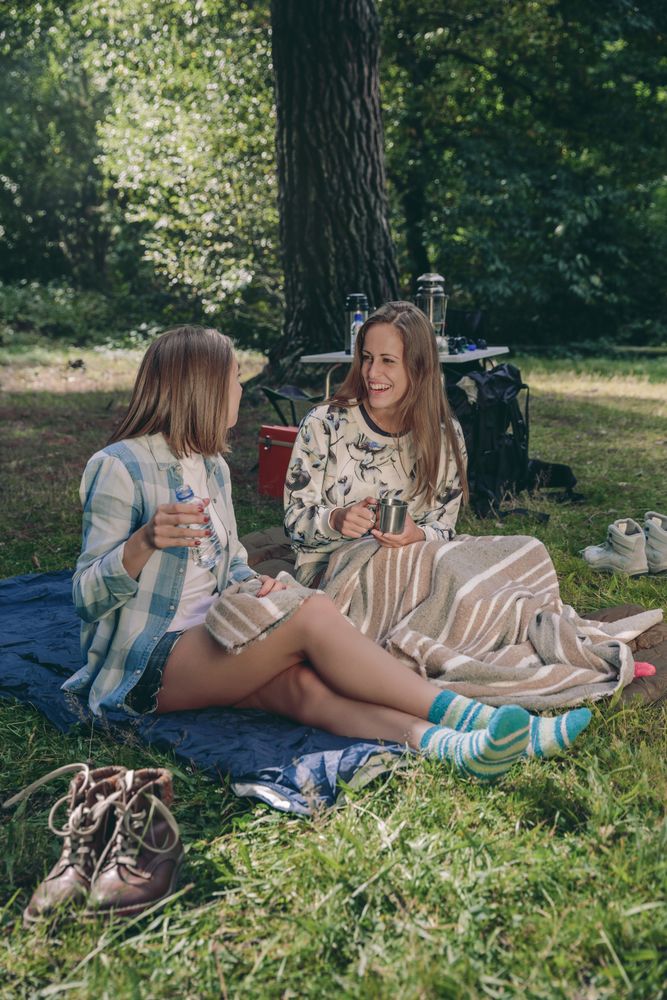 Women friends laughing sitting in the campsite