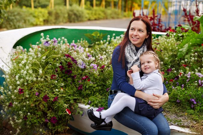Mother sitting in park with young blonde daughter