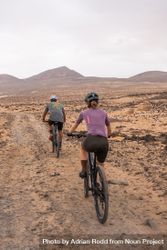 Back of man and woman biking on rugged terrain 4ABl6b