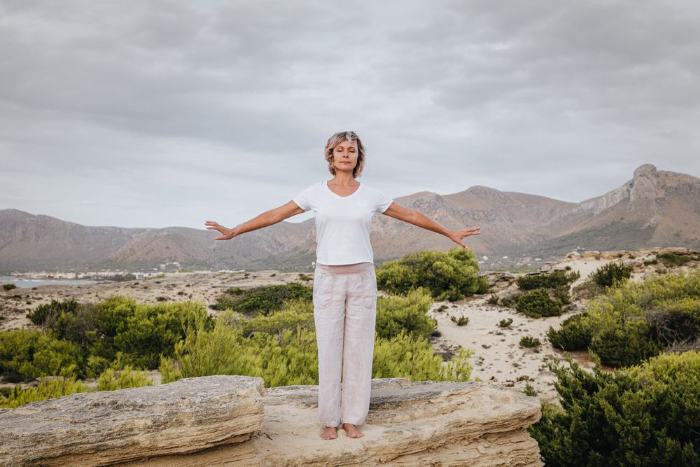 Barefoot woman meditating on stone