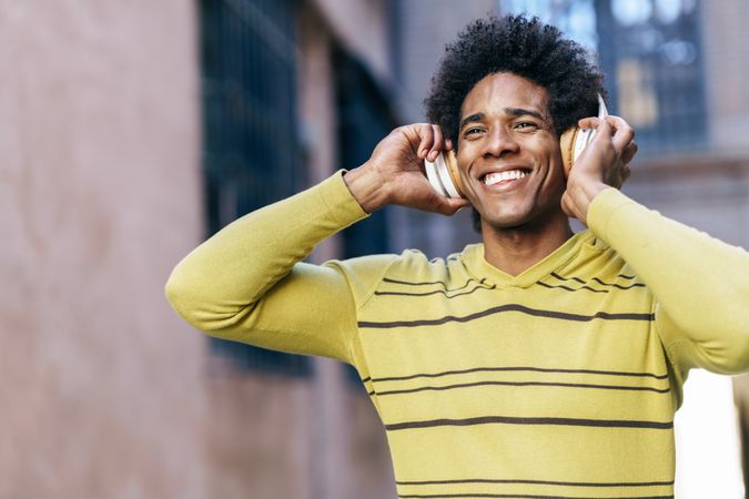 Happy man holding headphones to his ears