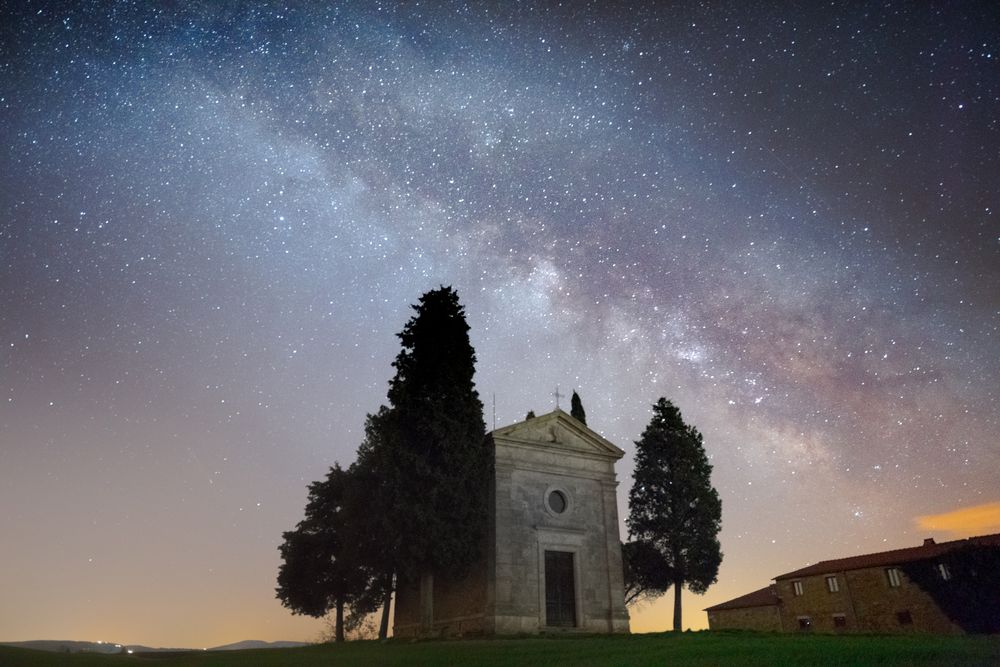 Single chapel among trees on field under stars